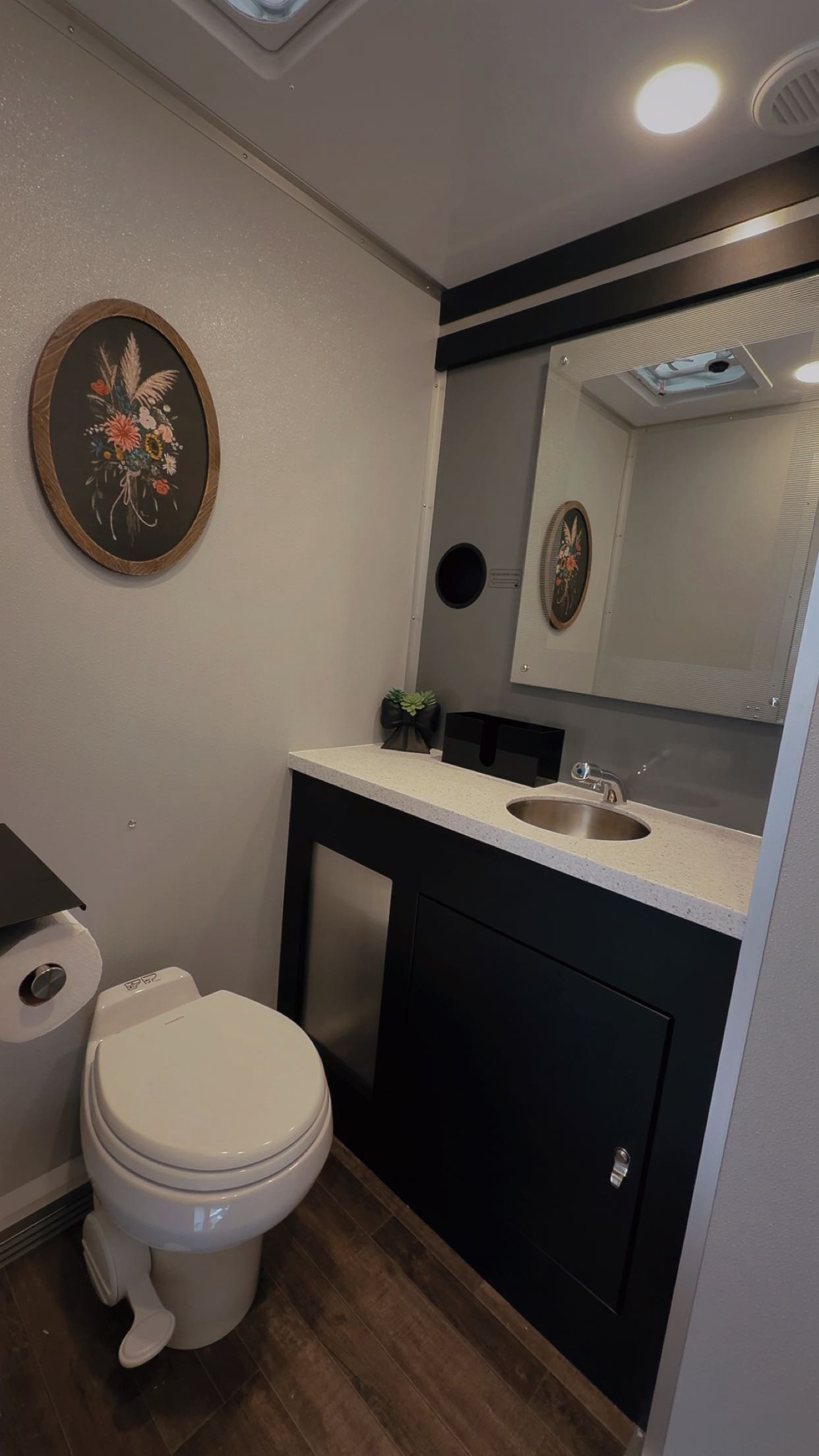Private restroom suite with black vanity and floral decor