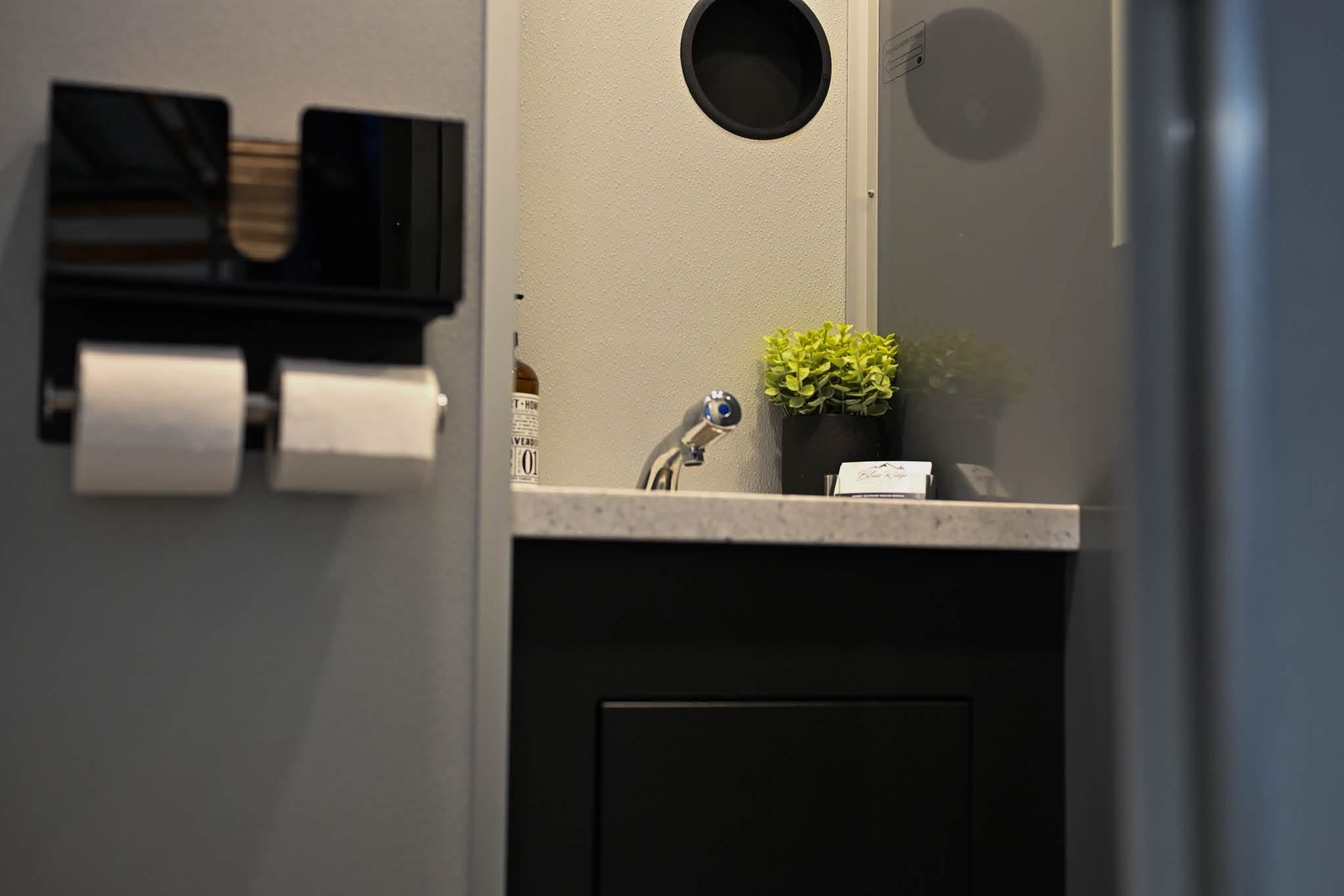 Restroom trailer vanity, mirror and stocked paper supplies