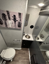 Restroom trailer suite with toilet and vanity